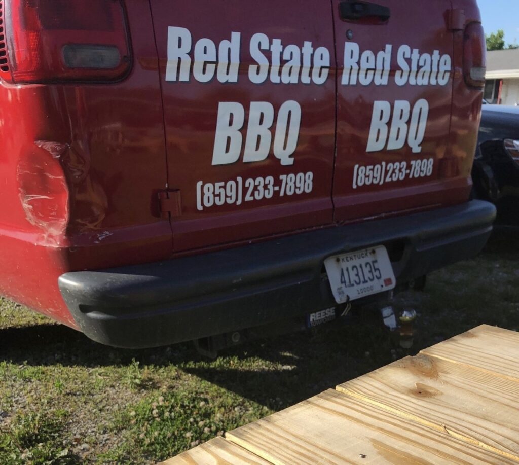 red delivery truck with restaurant name and phone number